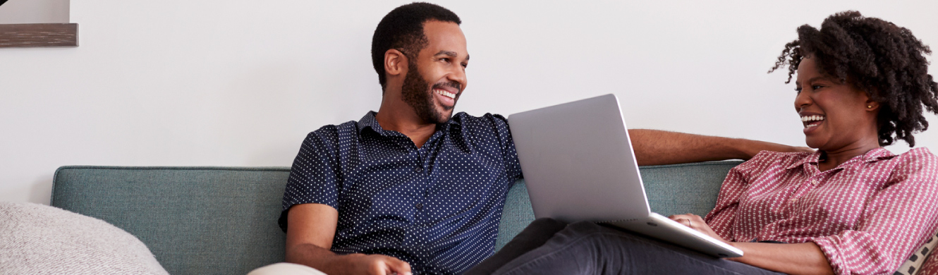 A couple on couch using laptop